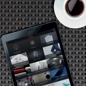 Vīrietis, kurš viedtālrunī iestata tvaika cepeškrāsns temperatūru, izmantojot lietotni my AEG