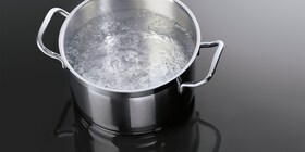 Katliņš ar verdošu ūdeni uz AEG indukcijas plīts