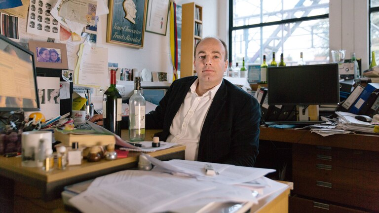 Čārlzs Spenss savā universitātes kabinetā